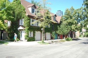 The faux-historic townhouses of the neighbourhood, built in 1980, have begun to look more authentically historic as the street trees mature and ivy climbs the outside walls. Author photo, June 2012.