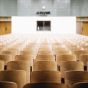 A lecture hall with wooden chairs