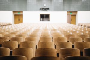 A lecture hall with wooden chairs