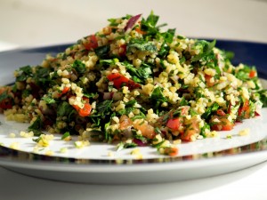 Tabbouleh is a Mezzeh (appetizer) made of cracked wheat with parsley, tomato, lemon, cucumbers, onion, and olive oil. Variations exist throughout the Levant