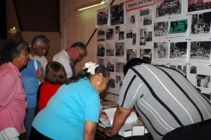 Gathering participants looking at residential school photographs during the Shingwauk 2006 Reunion. 
