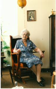 Elderly woman in a blue dress sitting in a rocking chair