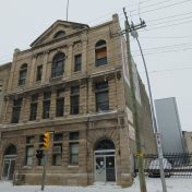 An image of a large grey stone building, built in a classical style.
