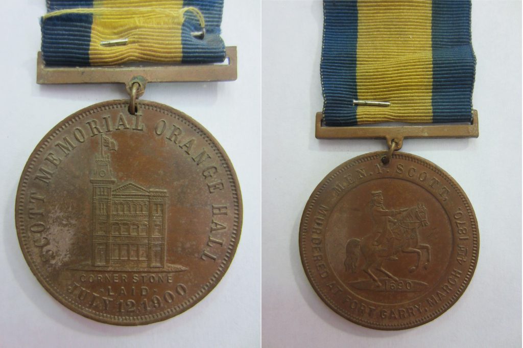 Two sides of a medal. One side is engraved with an image of a building and the words “Thomas Scott Memorial Hall”, the other with the image of a man on a horse and the words “Men.Y.Scott, Murdered at Fort Garry, 4 March, 1870.”