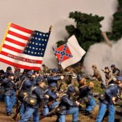 A miniature model of a Civil War battlefield, featuring model soldiers with Union and Confederate flags.