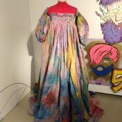 A multicoloured dress on a hot pink mannequin.