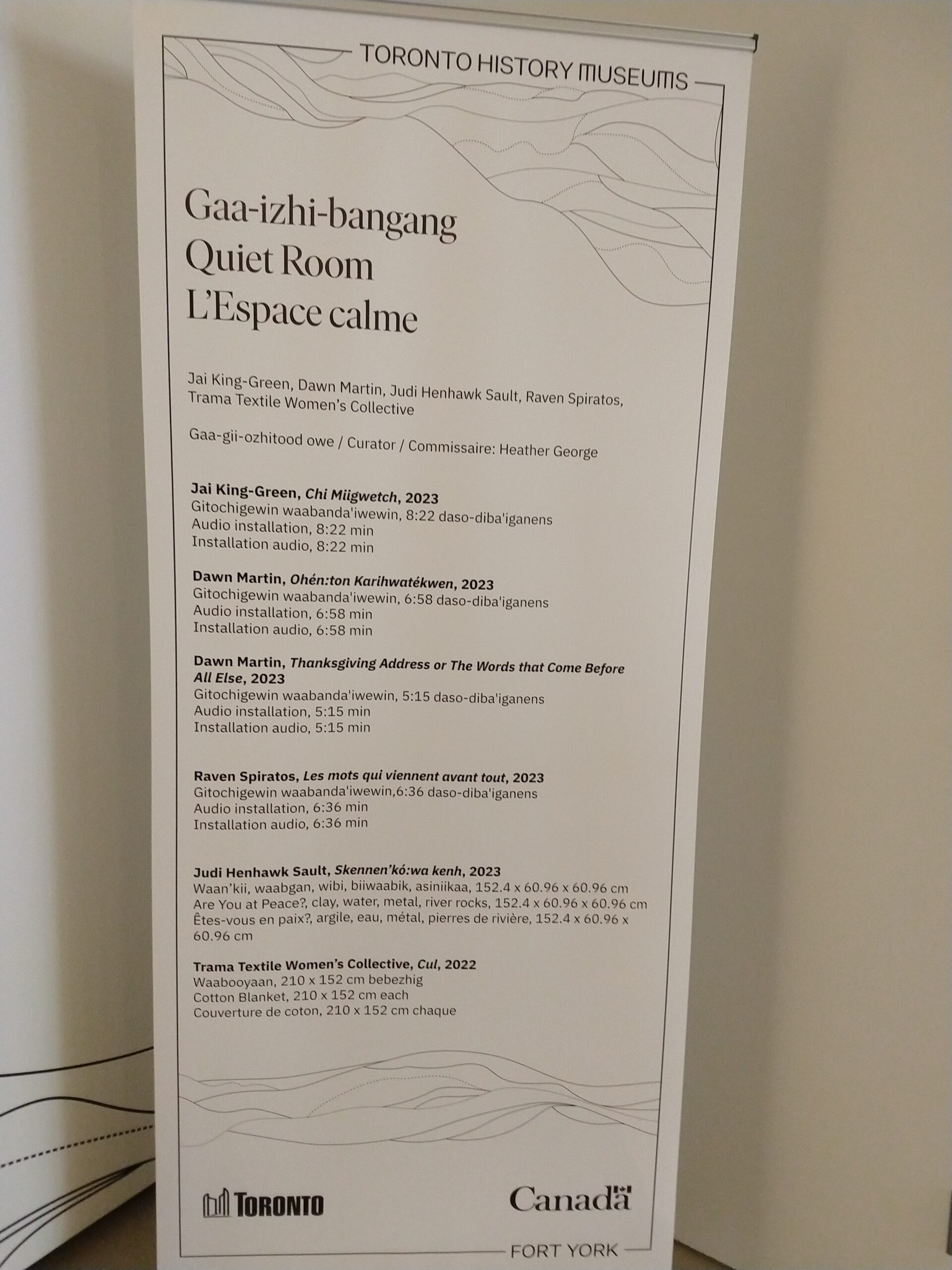 A white poster with black text enumerating exhibit contributors.