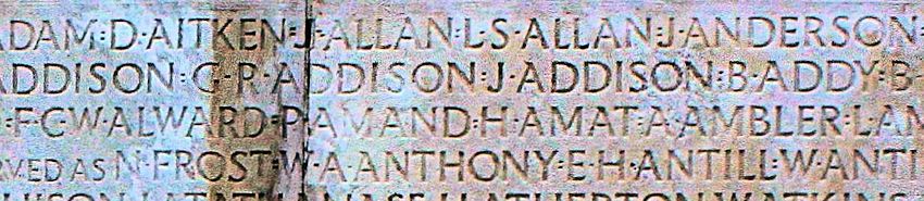 Close-up photograph of names engraved on the limestone walls of the Vimy Memorial in France.  The carved names show weathering and discoloration across the white stone surface, with variations in shadowing that highlight the depth of the engravings