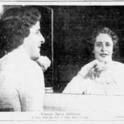 A black-and-white newspaper photograph showing Frances Marie Jefferson, a young woman with short curly dark hair, seen from behind on the left side of the frame as she looks into a mirror. Her reflection is visible in the mirror, showing her smiling face and wearing a light-coloured top with a ruffled or lacy collar.