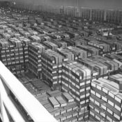 Black and white photo of hundreds of stacked, labeled boxes, viewed from above.